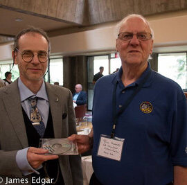 Bill Almond presents a copy of his Victoria Centre history to RASC Archivist Randall Rosenfeld